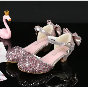 Détail de chaussures de princesse roses à paillettes avec nœud et pendentif pour filles