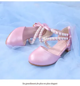 Detailed close-up of pink pearlescent girl shoes with pearl straps and bow details