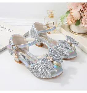 Detalle de sandalias con lentejuelas plateadas con triple lazo y perlas para niñas