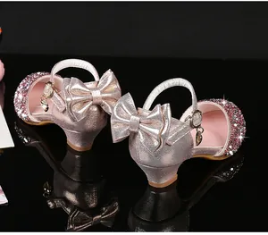 Détail de chaussures de fête rose doré à paillettes pour fille avec nœud et cœur