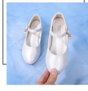 Détail de chaussures de princesse Mary Jane blanches pour filles avec perles et breloques