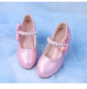 Close-up of pink Mary Jane shoes for girls with pearl strap and large bow detail