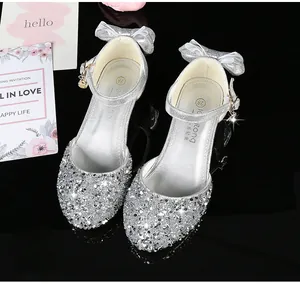 Détail de chaussures princesse pailletées argentées pour filles avec nœud et étoile