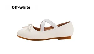 Detail of off-white Mary Jane girl shoes with bow accent and elastic cross straps