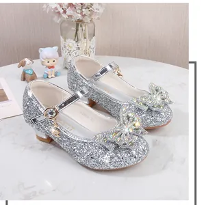 Nahaufnahme der silbernen Glitzerschuhe für Mädchen mit großen Strass-Schleifen