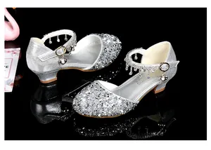 Detail of silver sequin girl princess shoes with rhinestone tassel and metallic buckle