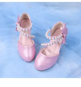 Close-up of pink girls' princess shoes with pearl straps and bow detail on mesh