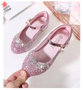 Gros plan de Mary Janes roses à paillettes avec bordure strass et perle