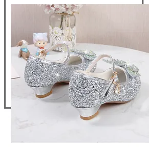 Makroaufnahme silberner Glitzer-Mary-Janes mit Pailletten-Schleifen und Strasssteinen