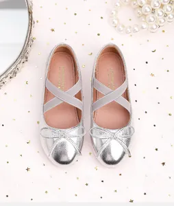 Close-up of silver glitter girls princess shoes with bow detail and elastic cross straps