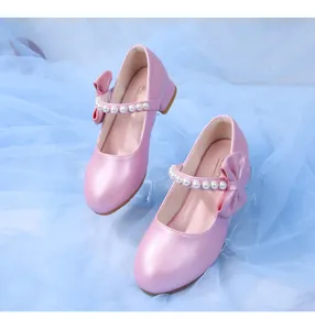 Detail of pink pearl Mary Jane shoes featuring a bow and decorative strap for girls