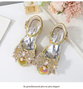 Detalle de sandalias doradas con purpurina, lazo de strass y colgante de perla