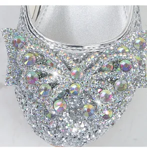Detail von silbernen Prinzessinnenschuhen mit Glitzerschleife und bunten Glitzersteinen