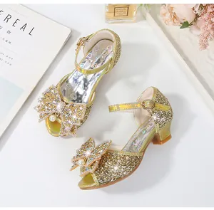 Detalle de zapatos de princesa dorados para niñas con lentejuelas, lazo y perla