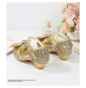 Vista de detalle de zapatos dorados con lentejuelas para niñas con lazo y tacón bajo