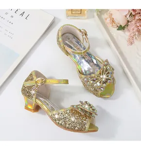 Detail view of sparkling gold sequined girls' princess sandals with diamond bow decoration