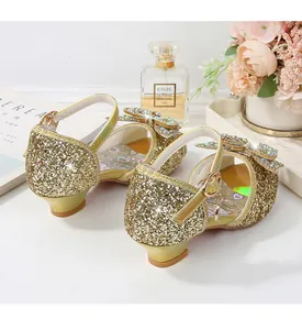 Detail of girls gold glitter Mary Jane shoes featuring a rhinestone bow and low heel