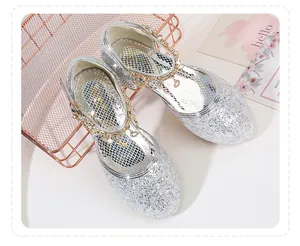 Detail of silver sequin princess shoes with a gold chain heart charm ankle strap