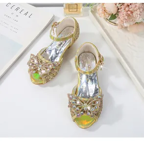Detail of girls gold sequin heels with a sparkling rhinestone bow and glitter finish