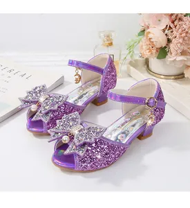 Detalle de zapato de princesa morado con lentejuelas, lazo de perlas y colgante de luna
