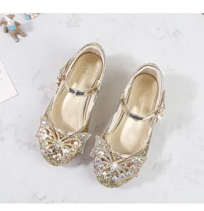 Detaillierte Draufsicht auf goldene Pailletten-Prinzessinenschuhe mit Strass-Schmetterling
