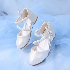 Pearlescent white girls mary jane shoes with pearl straps and bow detail on mesh background