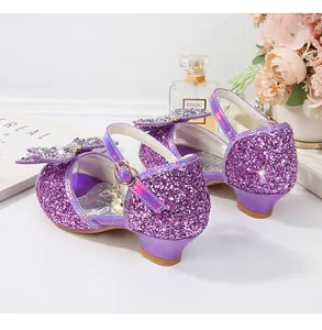 Detalle de lentejuelas púrpuras y lazo de strass en zapato de princesa para niña