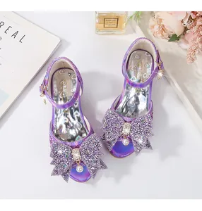 Detalle de sandalia princesa de lentejuelas moradas con lazo de cristal y perla