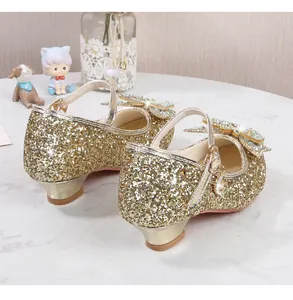Detailansicht der goldenen Pailletten-Prinzessinenschuhe mit Schmetterlings-Strass-Schnalle