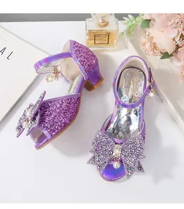 Detalle de sandalias moradas de lentejuelas para niña con lazo de strass y perlas