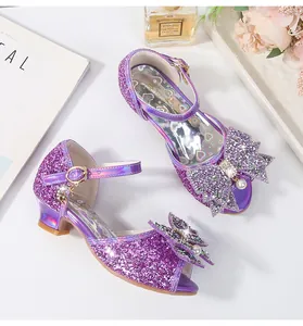 Detalle de sandalias moradas con lentejuelas para niña con lazo de perlas y dije de luna