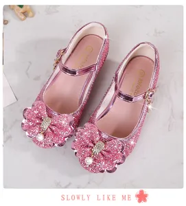 Dettaglio scarpe Mary Jane rosa con glitter, fiocco di strass e decorazioni di perle