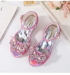 Detail of glitter girls princess sandals with large rhinestone bow on white background