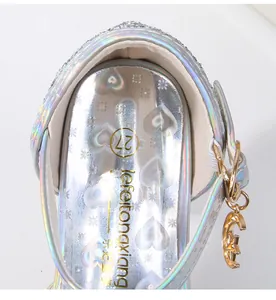 Detalle de zapato de princesa plateado para niña con plantilla holográfica y colgante