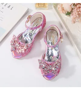 Macro view of pink sequin girls' sandals with rhinestone bow and heart-printed insole