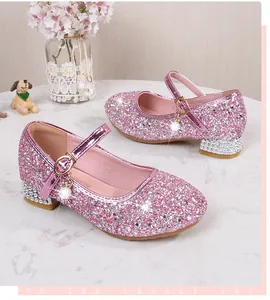 Detail von rosa Glitzer Mary Jane Schuhen mit Perlenanhänger und Strass-Blockabsatz