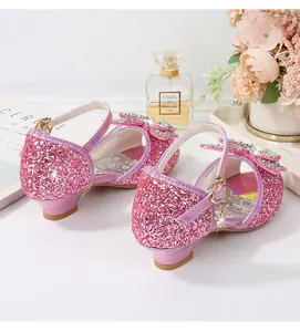 Close-up of pink glitter girls' sandals with sparkling rhinestone bow and star charm