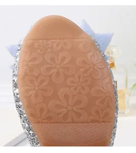 Detalle de la suela de goma antideslizante con margaritas para zapatos de niña plateados