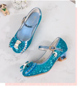 Macro detail of sequined blue Mary Jane shoes with star and moon charms