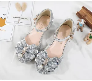 Close-up of silver sequin girls' princess shoes with pearl bow and diamond accents