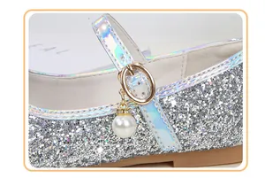 Close-up of girls silver sequin Mary Jane shoes with laser trim and pearl charm