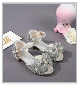 Detailed view of silver sequin girls sandals with a large bow and sparkly glitter texture