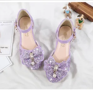 Close-up of girls purple sequin Mary Jane shoes with rhinestone bow and ankle strap