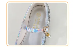 Detail of silver sequin Mary Jane shoes with holographic strap and pearl rhinestone charm
