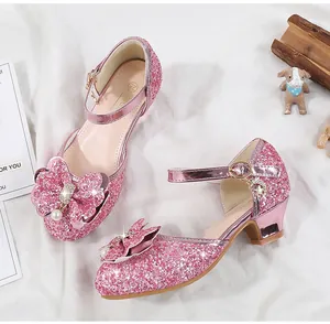 Detailed view of pink sequin girls' shoes with pearl bow and moon pendant strap