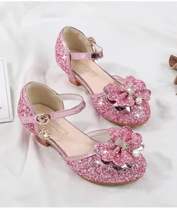 Detail of pink glitter girls princess shoes with bow, pearls and moon pendant charm