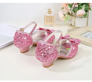 Close-up of pink sequined girls princess shoes with bow and heart charm details