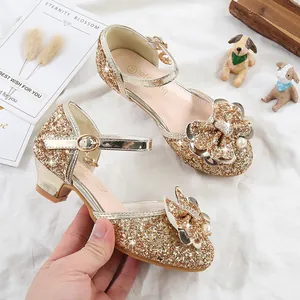 Detailed shot of golden girls princess shoe with sequins, pearls and bow decoration