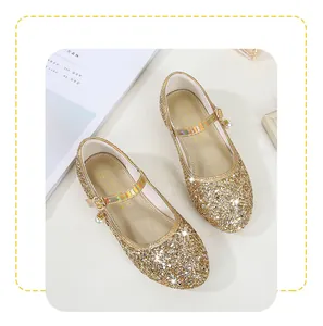 Detailed shot of golden sequined Mary Jane princess shoes with a white pearl charm