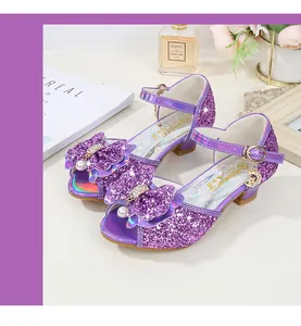 Close-up of girls purple sequin princess sandals with bow and pearl decorations